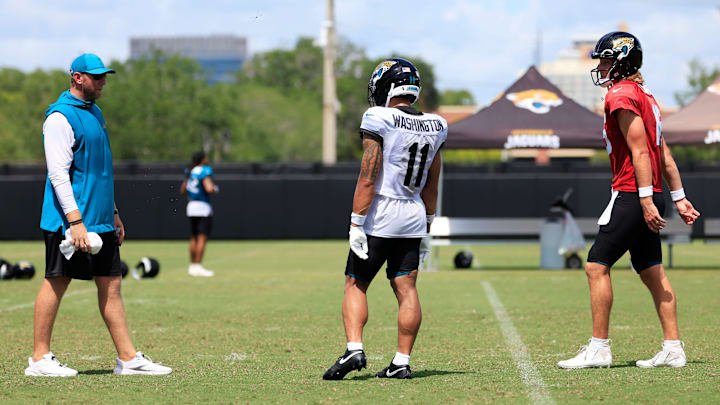 From left, Jacksonville Jaguars head coach Liam Coen, wide receiver Parker Washington (11) and quarterback Trevor Lawrence (16) talk after an NFL training camp session at the Miller Electric Center, Thursday, Aug. 14, 2025 in Jacksonville, Fla.