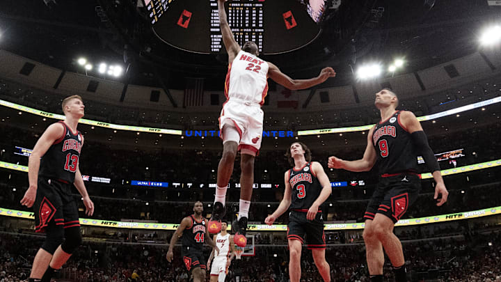 Apr 16, 2025; Chicago, Illinois, USA; Miami Heat forward Andrew Wiggins (22) goes to the basket as Chicago Bulls center Nikola Vucevic (9) defends him during the first quarter at United Center. Mandatory Credit: David Banks-Imagn Images