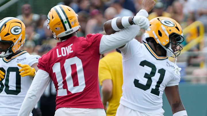 Green Bay Packers quarterback Jordan Love (10) and running back Emanuel Wilson (31) exchange greetings during practice on Thursday.