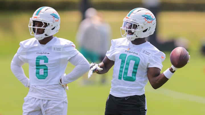Miami Dolphins wide receiver Tyreek Hill (10) tosses a football as wide receiver Malik Washington (6) looks on during mandatory minicamp at Hard Rock Stadium.