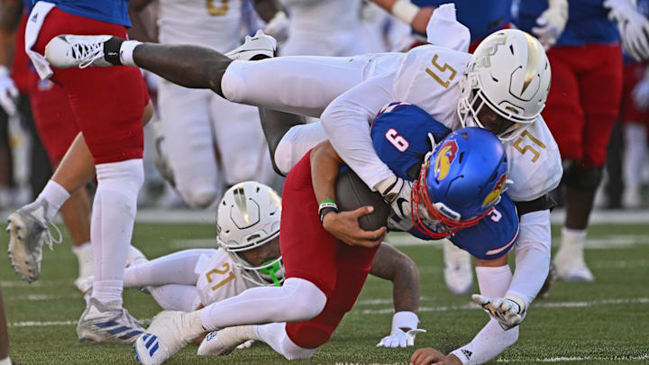 Oct 7, 2023; Lawrence, Kansas, USA;  UCF Knights defensive end Malachi Lawrence (51) tackles Kansas Jayhawks quarterback Jason Bean (9) during the second half at David Booth Kansas Memorial Stadium. Mandatory Credit: Peter Aiken-Imagn Images