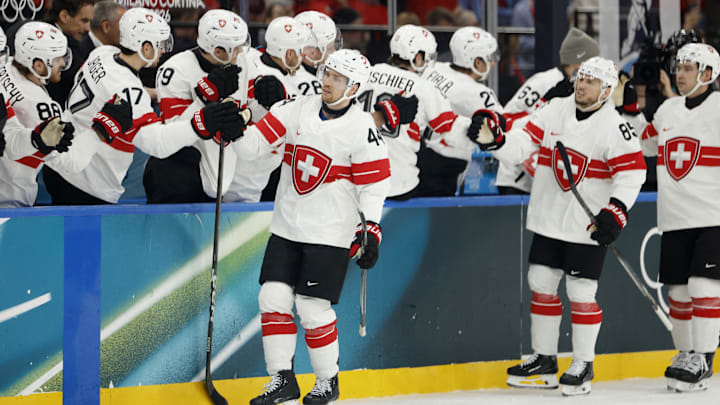 Feb 13, 2026; Milan, Italy;  Pius Suter of Switzerland celebrates with teammates after scoring their first goal against Canada in men's ice hockey group A play during the Milano Cortina 2026 Olympic Winter Games at Milano Santagiulia Ice Hockey Arena. Mandatory Credit: Geoff Burke-Imagn Images