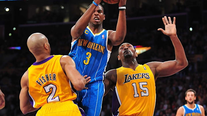 April 26, 2011; Los Angeles, CA, USA; New Orleans Hornets point guard Chris Paul (3) moves the ball against the defense of Los Angeles Lakers point guard Derek Fisher (2) and small forward Ron Artest (15) in the first half of game five of the 2011 NBA playoffs  at the Staples Center. Mandatory Credit: Gary A. Vasquez-Imagn Images
