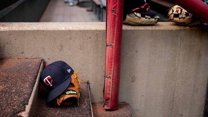 Minnesota Twins hats and gloves sit on the steps of the dugout. Minnesota Twins hats and gloves sit on the steps of the dugout.