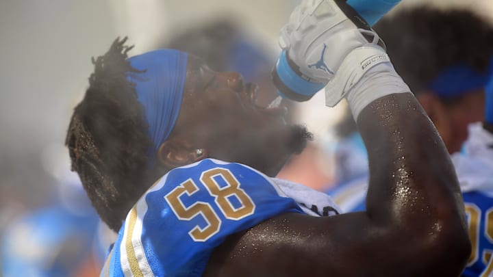 Sep 3, 2022; Pasadena, California, USA; UCLA Bruins defensive lineman Gary Smith III (58) drinks water and cools off at a misting station during the second half at Rose Bowl. Mandatory Credit: Gary A. Vasquez-Imagn Images