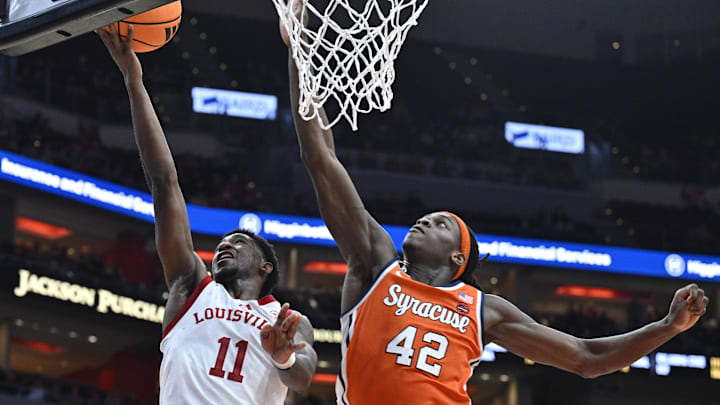 Mar 3, 2026; Louisville, Kentucky, USA;  Louisville Cardinals guard Kobe Rodgers (11) shoots against Syracuse Orange forward William Kyle III (42) during the second half at KFC Yum! Center. Louisville defeated Syracuse 77-62. Mandatory Credit: Jamie Rhodes-Imagn Images