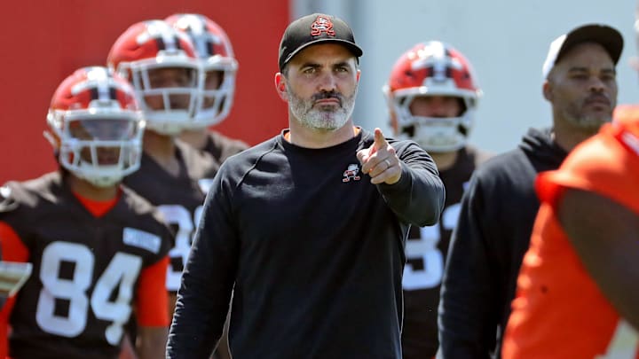 Cleveland Browns coach Kevin Stefanski watches quarterback Shedeur Sanders (12) participate in drills during day two of NFL rookie minicamp at the Cleveland Browns training facility May 10, 2025, in Berea, Ohio.