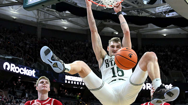  Mar 2, 2025; East Lansing, Michigan, USA;  Michigan State Spartans center Carson Cooper (15) makes a big dunk on a lob pass in front of Wisconsin Badgers forward Steven Crowl (22) during the second half at Jack Breslin Student Events Center. Mandatory Credit: Dale Young-Imagn Images