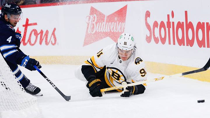 Oct 2, 2026; Winnipeg, Manitoba, CAN;  Winnipeg Jets defenseman Neal Pionk (4) and Boston Bruins defenseman Nikita Zadorov (91) chase after the puck during the second period at Canada Life Centre.  Mandatory Credit: Terrence Lee-Imagn Images