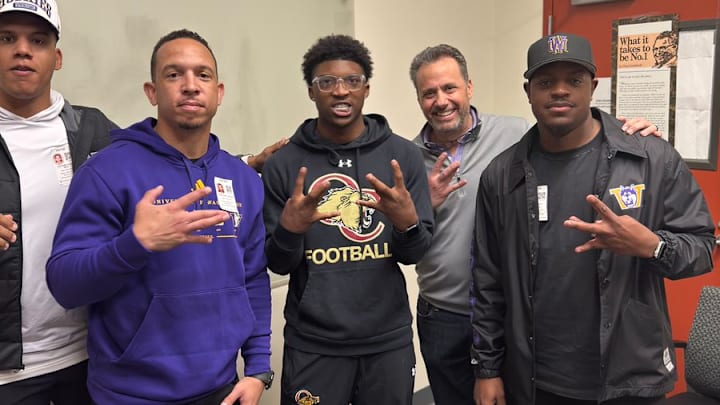 Davon Benjamin, center spends time with UW coaches Taylor Mays, Ryan Walters, Jedd Fisch and John Richardson. 