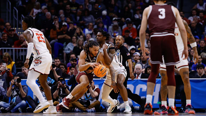 Mar 20, 2025; Denver, CO, USA; Wisconsin Badgers forward Xavier Amos (13) defends against Montana Grizzlies guard Joe Pridgen (11) during the first half in the first round of the NCAA Tournament at Ball Arena. Mandatory Credit: Isaiah J. Downing-Imagn Images