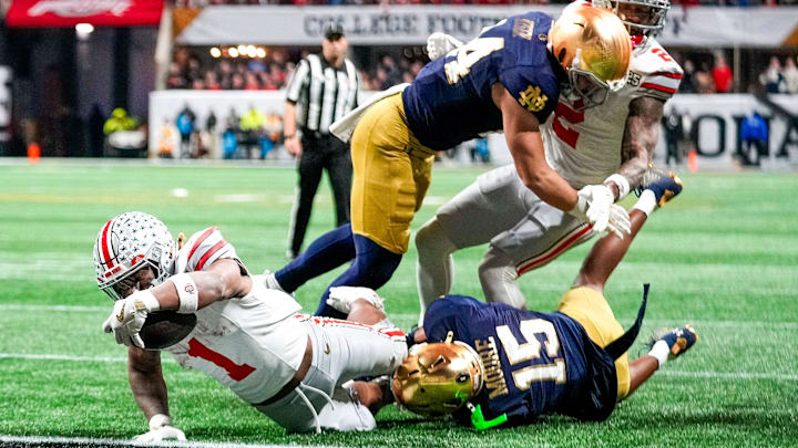 Ohio State Buckeyes running back Quinshon Judkins (1) scores a rushing touchdown against Notre Dame Fighting Irish cornerback Leonard Moore (15) in the second quarter during the College Football Playoff National Championship at Mercedes-Benz Stadium in Atlanta on January 20, 2025.