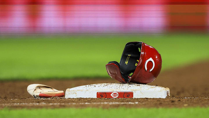 Jul 29, 2024; Cincinnati, Ohio, USA; The helmet and sliding glove of Cincinnati Reds catcher Tyler Stephenson (not pictured) sits on first base during a stop in play in the eighth inning in the game against the Chicago Cubs at Great American Ball Park. Mandatory Credit: Katie Stratman-Imagn Images