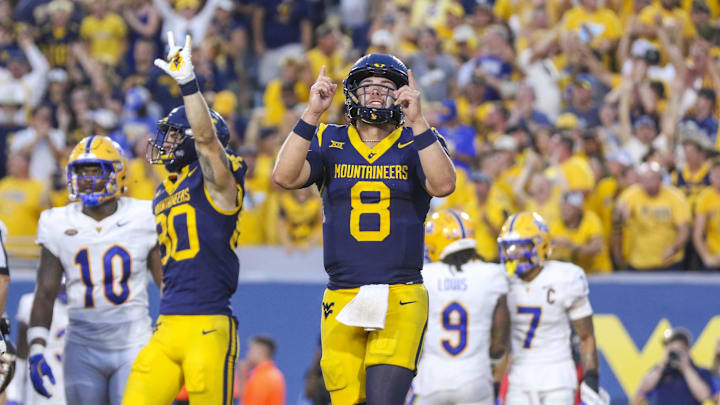 Sep 13, 2025; Morgantown, West Virginia, USA; West Virginia Mountaineers quarterback Nicco Marchiol (8) celebrates after throwing a pass for a touchdown during the fourth quarter against the Pittsburgh Panthers at Milan Puskar Stadium. Mandatory Credit: Ben Queen-Imagn Images