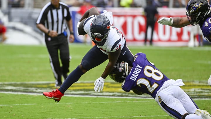 Sep 10, 2023; Baltimore, Maryland, USA; Baltimore Ravens cornerback Ronald Darby (28) tackles Houston Texans running back Devin Singletary (26) during the second half at M&T Bank Stadium. Mandatory Credit: Brad Mills-USA TODAY Sports
