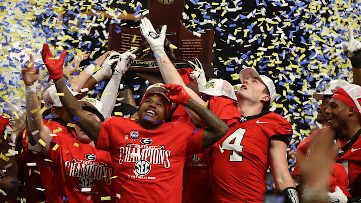 The Georgia Bulldogs celebrate with the trophy after defeating the Texas Longhorns in overtime in the 2024 SEC Championship game at Mercedes-Benz Stadium. The Georgia Bulldogs celebrate with the trophy after defeating the Texas Longhorns in overtime in the 2024 SEC Championship game at Mercedes-Benz Stadium.