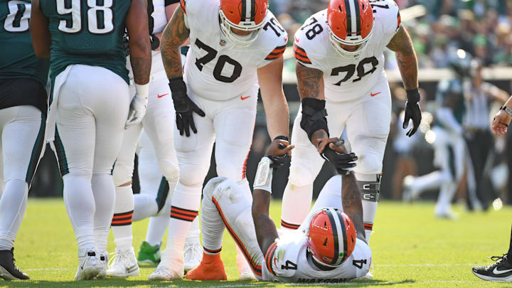 Oct 13, 2024; Philadelphia, Pennsylvania, USA; Cleveland Browns quarterback Deshaun Watson (4) is helped up by guard Zak Zinter (70) and offensive tackle Jack Conklin (78) against the Philadelphia Eagles during the second quarter at Lincoln Financial Field. Mandatory Credit: Eric Hartline-Imagn Images