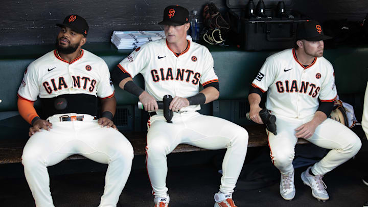 Aug 14, 2024; San Francisco, California, USA; San Francisco Giants left fielder Heliot Ramos (from left), shortstop Tyler Fitzgerald and second baseman Brett Wisely sit in the dugout before taking on the Atlanta Braves at Oracle Park.