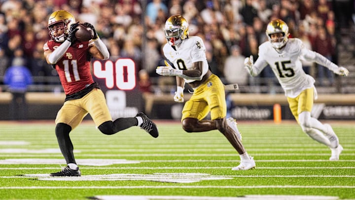 Nov 1, 2025; Chestnut Hill, Massachusetts, USA; Boston College Eagles wide receiver Lewis Bond (11) catches a pass against Notre Dame Fighting Irish safety Adon Shuler (8) and defensive back Leonard Moore (15) in the fourth quarter at Alumni Stadium. Mandatory Credit: Edward Finan-Imagn Images