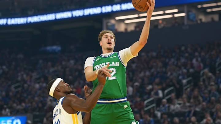 Dec 25, 2025; San Francisco, California, USA; Dallas Mavericks forward Cooper Flagg (center) shoots against Golden State Warriors forward Jimmy Butler III (10) during the first quarter at Chase Center. Mandatory Credit: Darren Yamashita-Imagn Images