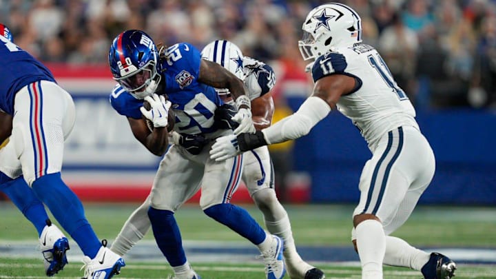 Sep 26, 2024; East Rutherford, NJ, US; New York Giants running back Eric Gray (20) runs out of the backfield with the ball while being tackled by Dallas Cowboys linebacker Eric Kendricks (50) at MetLife Stadium.  