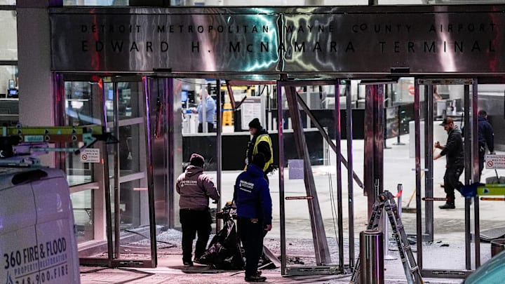Workers clean up damage near the international ticketing gate of Detroit Metro Airport McNamara Terminal after a car drove into the building in Romulus on Friday, Jan. 23, 2026.