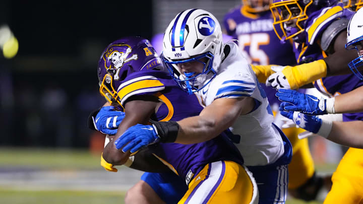 Sep 20, 2025; Greenville, North Carolina, USA;  East Carolina Pirates running back Parker Jenkins (5) is stopped on his run by Brigham Young Cougars defensive end Hunter Clegg (90) during the second half at Dowdy-Ficklen Stadium. Mandatory Credit: James Guillory-Imagn Images