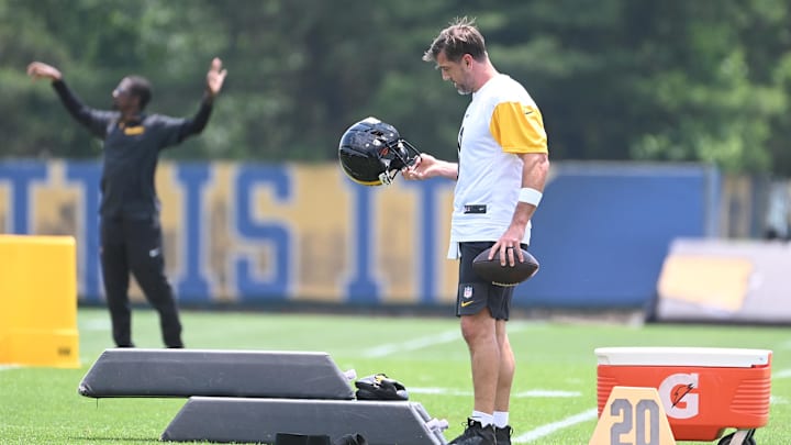Jun 10, 2025; Pittsburgh, PA, USA;  Pittsburgh Steelers quarterback Aaron Rodgers (8) looks over his helmet during minicamp at their South Side facility. Mandatory Credit: Philip G. Pavely-Imagn Images