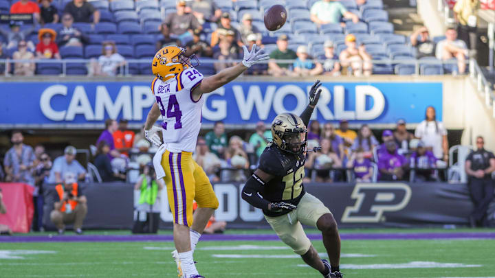 Jan 2, 2023; Orlando, FL, USA; LSU Tigers wide receiver Landon Ibieta (24) jumps for a pass in front of Purdue Boilermakers safety Jah'Von Grigsby (12) during the second half at Camping World Stadium. Mandatory Credit: Mike Watters-Imagn Images