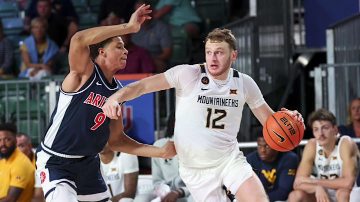 Nov 29, 2024; Paradise Island, Bahamas, BHS;  West Virginia Mountaineers guard Tucker DeVries (12) drives to the basket as Arizona Wildcats forward Carter Bryant (9) defends during the second half at Imperial Arena at the Atlantis resort.  Mandatory Credit: Kevin Jairaj-Imagn Images
