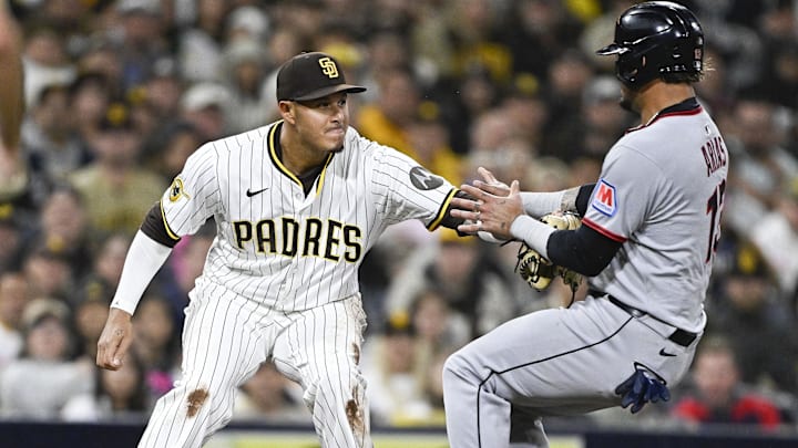 Mar 31, 2025; San Diego, California, USA; San Diego Padres third baseman Manny Machado (13) tags Cleveland Guardians third baseman Gabriel Arias (13) out at third base during the fifth inning at Petco Park. Mandatory Credit: Denis Poroy-Imagn Images