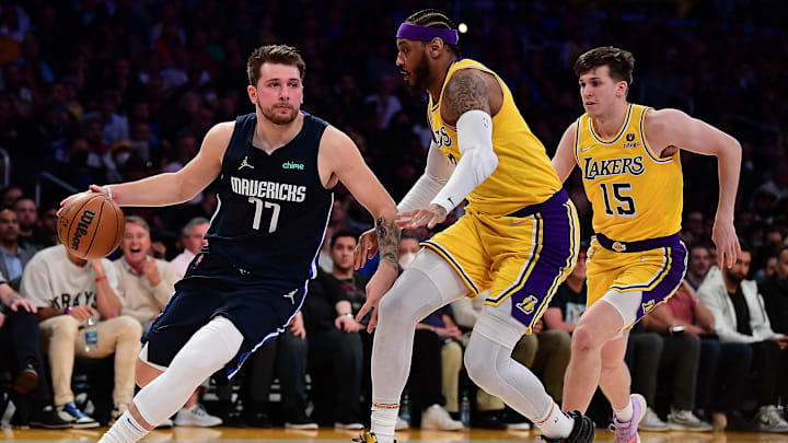 Mar 1, 2022; Los Angeles, California, USA; Dallas Mavericks guard Luka Doncic (77) moves to the basket against Los Angeles Lakers forward Carmelo Anthony (7) and guard Austin Reaves (15) during the first half at Crypto.com Arena. Mandatory Credit: Gary A. Vasquez-Imagn Images