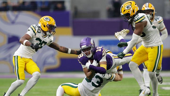 Minnesota Vikings wide receiver Justin Jefferson (18) dives for a first down on a reception against Green Bay Packers safety Evan Williams (33) during their football game Sunday, January 4, 2026, at U.S. Bank Stadium in Minneapolis, Minnesota.