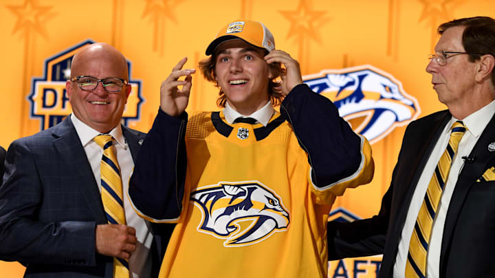 Jun 28, 2023; Nashville, Tennessee, USA; Nashville Predators draft pick Tanner Molendyk puts on a hat after being selected with the twenty fourth pick in round one of the 2023 NHL Draft at Bridgestone Arena. Mandatory Credit: Christopher Hanewinckel-Imagn Images