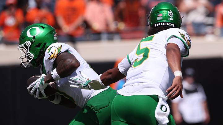 Sep 12, 2026; Stillwater, Oklahoma, USA;  Oregon Ducks quarterback Dante Moore (5) hands off to running back Jordon Davison (0) and Davison goes in for a touchdown during the second quarter against the Oklahoma State Cowboys at Boone Pickens Stadium.  Mandatory Credit: William Purnell-Imagn Images