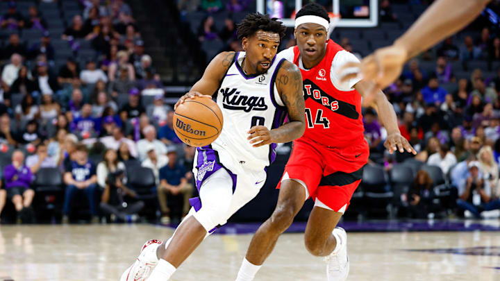 Oct 8, 2025; Sacramento, California, USA; Sacramento Kings guard Malik Monk (0) dribbles the ball up the court against Toronto Raptors guard Ja'Kobe Walter (14) during the second quarter at Golden 1 Center. Mandatory Credit: Sergio Estrada-Imagn Images