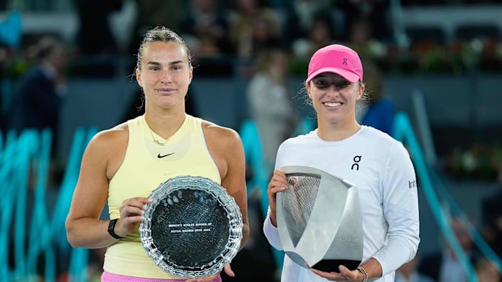 Aryna Sabalebka and Iga Swiatek hold trophies at the 2024 Mutua Madrid Open.