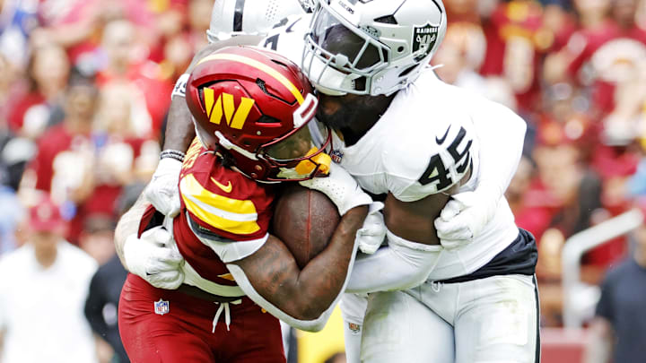 Sep 21, 2025; Landover, Maryland, USA; Washington Commanders defensive back Car'Lin Vigers (22) is tackled by Las Vegas Raiders linebacker Devin White (45) during the first half at Northwest Stadium. Mandatory Credit: Amber Searls-Imagn Images