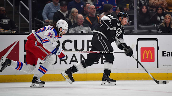 Jan 20, 2024; Los Angeles, California, USA; Los Angeles Kings defenseman Vladislav Gavrikov (84) moves the puck ahead of New York Rangers center Mika Zibanejad (93) durng the first period at Crypto.com Arena. Mandatory Credit: Gary A. Vasquez-Imagn Images