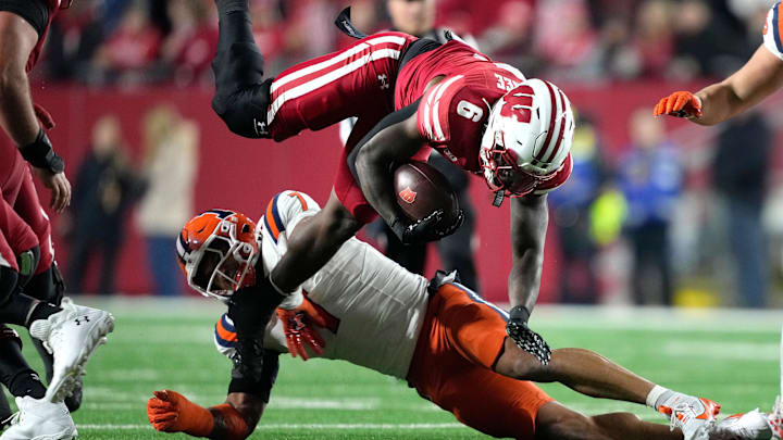 Nov 22, 2025; Madison, Wisconsin, USA; Wisconsin Badgers running back Darrion Dupree (6) is tackled by Illinois Fighting Illini defensive back Matthew Bailey (7) during the first quarter at Camp Randall Stadium. Mandatory Credit: Kayla Wolf-Imagn Images