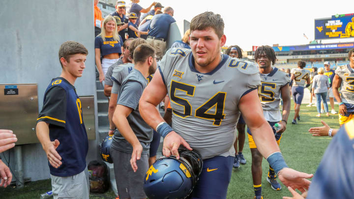 Sep 17, 2022; Morgantown, West Virginia, USA; West Virginia Mountaineers offensive lineman Zach Frazier (54) celebrates with fans after defeating the Towson Tigers at Mountaineer Field at Milan Puskar Stadium. Mandatory Credit: Ben Queen-USA TODAY Sports