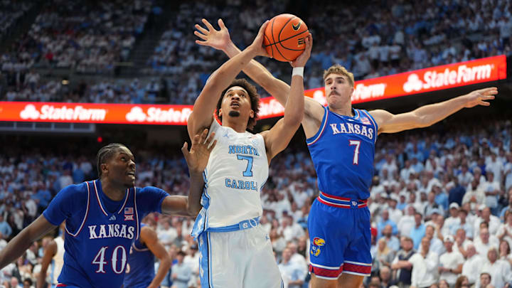 Nov 7, 2025; Chapel Hill, North Carolina, USA;  North Carolina Tar Heels guard Seth Trimble (7) shoots as Kansas Jayhawks forward Flory Bidunga (40) and guard Kohl Rosario (7) defend in the second half at Dean E. Smith Center. Mandatory Credit: Bob Donnan-Imagn Images