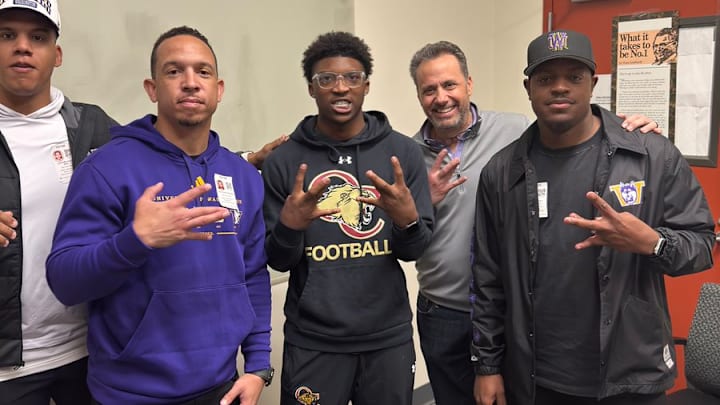 Davon Benjamin, center spends time with UW coaches Taylor Mays, Ryan Walters, Jedd Fisch and John Richardson. 