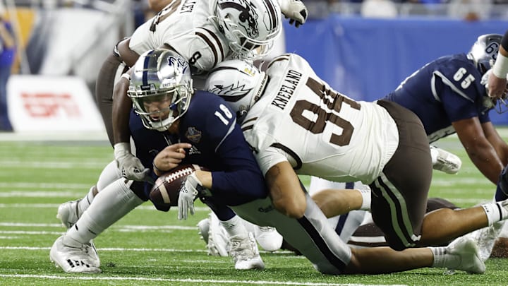 Dec 27, 2021; Detroit, MI, USA; Nevada Wolf Pack quarterback Nate Cox (16) is sacked by Western Michigan edge Marshawn Kneeland (94).
