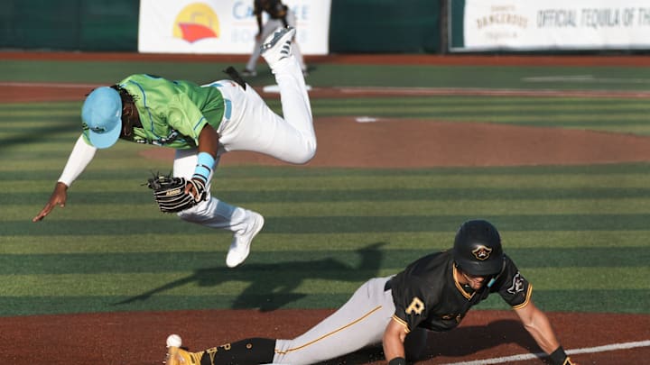 Daytona Tortugas third baseman Carlos Sanchez (33) jumps over sliding Bradenton Marauders player Konnor Griffin (6), Friday, April 4, 2025 at Jackie Robinson Ballpark in Daytona Beach.