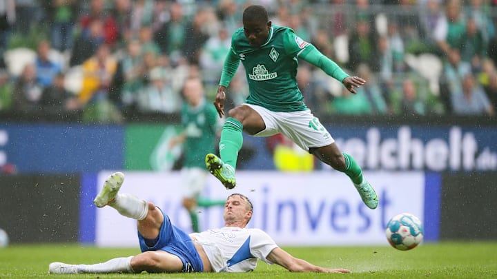 Roger Assale (in grün) springt über die Grätsche von Rostocks Thomas Meissner (in weiß).