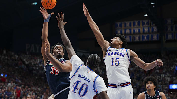 Feb 7, 2026; Lawrence, Kansas, USA; Arizona Wildcats forward Tobe Awaka (30) shoots against Kansas Jayhawks forward Flory Bidunga (40) and forward Bryson Tiller (15) during the first half at Allen Fieldhouse. Mandatory Credit: Jay Biggerstaff-Imagn Images