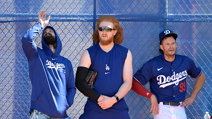 Feb 18, 2024; Glendale, AZ, USA;  Los Angeles Dodgers starting pitcher Tony Gonsolin (26), starting pitcher Dustin May (85) and relief pitcher Joe Kelly (99) lean on a fence in the bull pen during spring training at Camelback Ranch. Mandatory Credit: Jayne Kamin-Oncea-Imagn Images