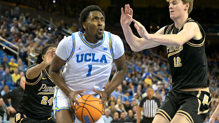 Jan 20, 2026; Los Angeles, California, USA;  UCLA Bruins forward Xavier Booker (1) is defended by Purdue Boilermakers guard Gicarri Harris (24) and center Daniel Jacobsen (12) as he drives to the basket in the first half at Pauley Pavilion presented by Wescom Financial. Mandatory Credit: Jayne Kamin-Oncea-Imagn Images