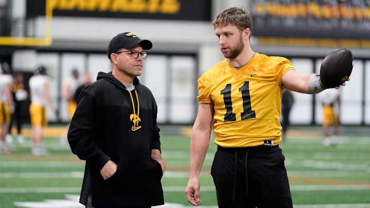 Iowa's senior football analyst Warren Ruggiero, left, talks to quarterback Mark Gronowski (11) during practice Thursday, April 3, 2025 in Iowa City, Iowa.